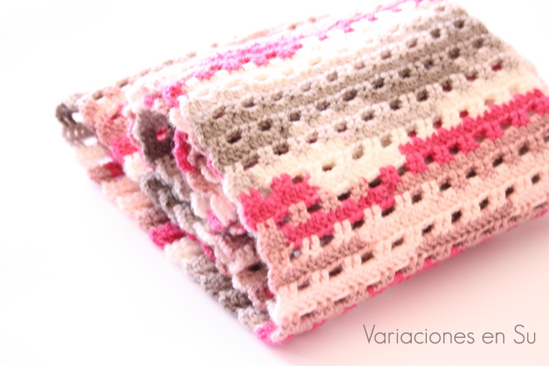 Bufanda de ganchillo tejida en punto calado con lana de tonos grises y rosas.
