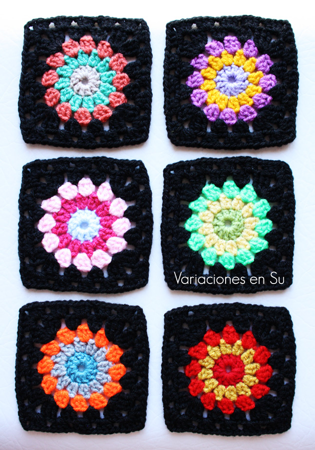 Granny squares o cuadrados de ganchillo tejidos con lana de llamativos colores combinados con negro.