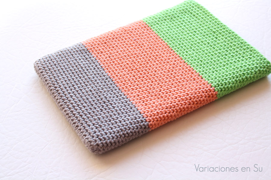 Funda de ganchillo para libro electrónico (e-reader) tejida en hilo de algodón en los colores gris, naranja y verde.