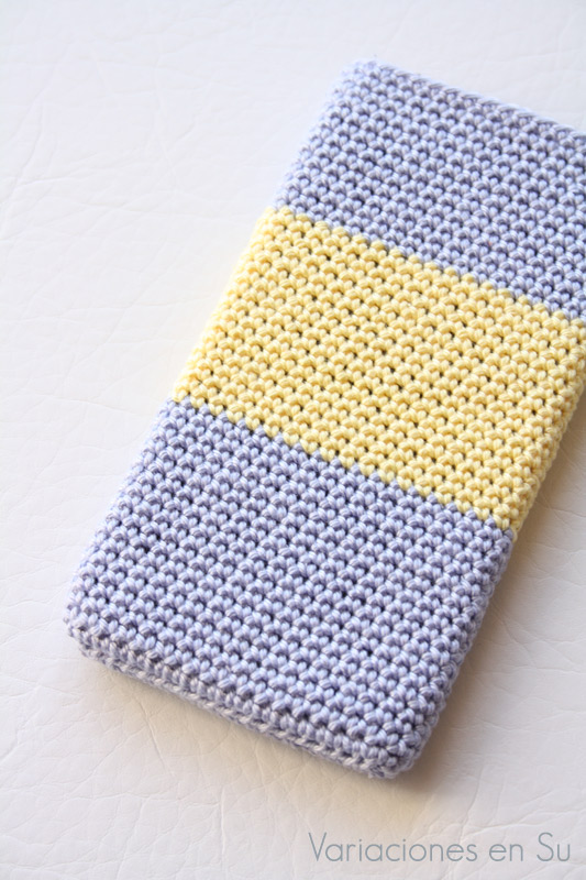Funda de ganchillo para móvil tejida en los colores malva y amarillo.