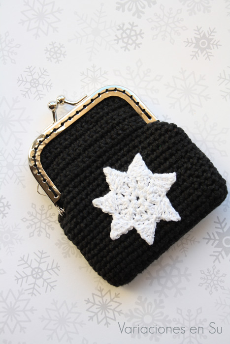 Monedero de ganchillo con estrella Monedero de ganchillo en color negro con figura de estrella en blanco y boquilla plateada.