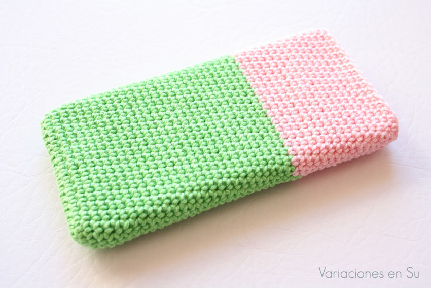 Funda para móvil tejida a ganchillo con hilo de algodón en los colores verde y rosa. 