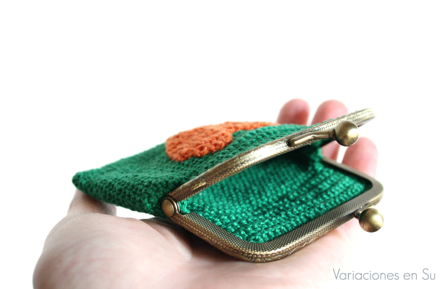 Monedero verde con corazón naranja (detalle) Monedero de ganchillo en color verde con figura de corazón en naranja y boquilla metálica de color bronce con filigrana.