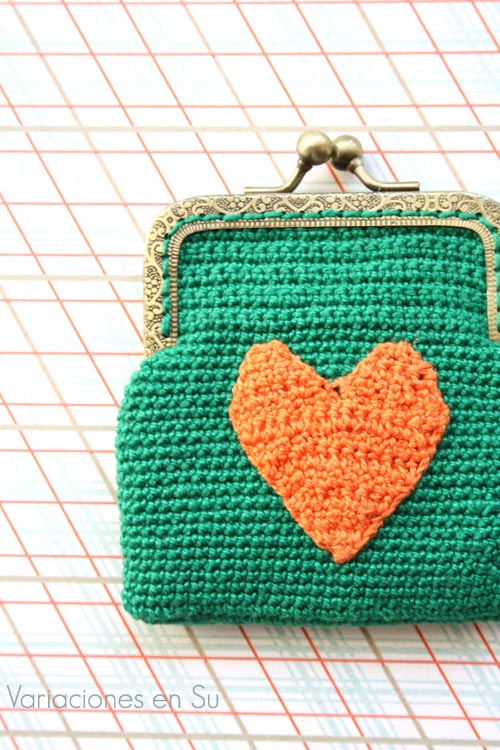 Monedero verde con corazón naranja Monedero de ganchillo en color verde con figura de corazón en naranja y boquilla metálica de color bronce con filigrana.
