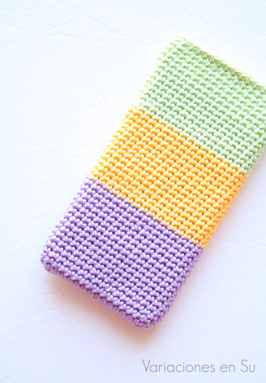 Funda para móvil tejida a ganchillo con hilo de algodón mercerizado en los colores malva, amarillo y verde. 